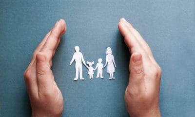 A family cut of paper representing foster care held in someone's hands