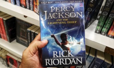 a person holding a percy jackson book