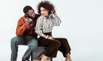 Man and woman using vintage old-school telephone and TV set