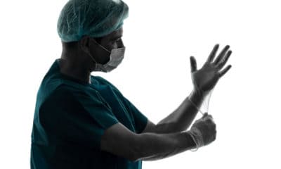Surgeon putting on latex gloves, preparing for surgery, Atul Gawande