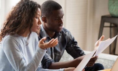 Couple in front of computer reviewing documents looking at debt